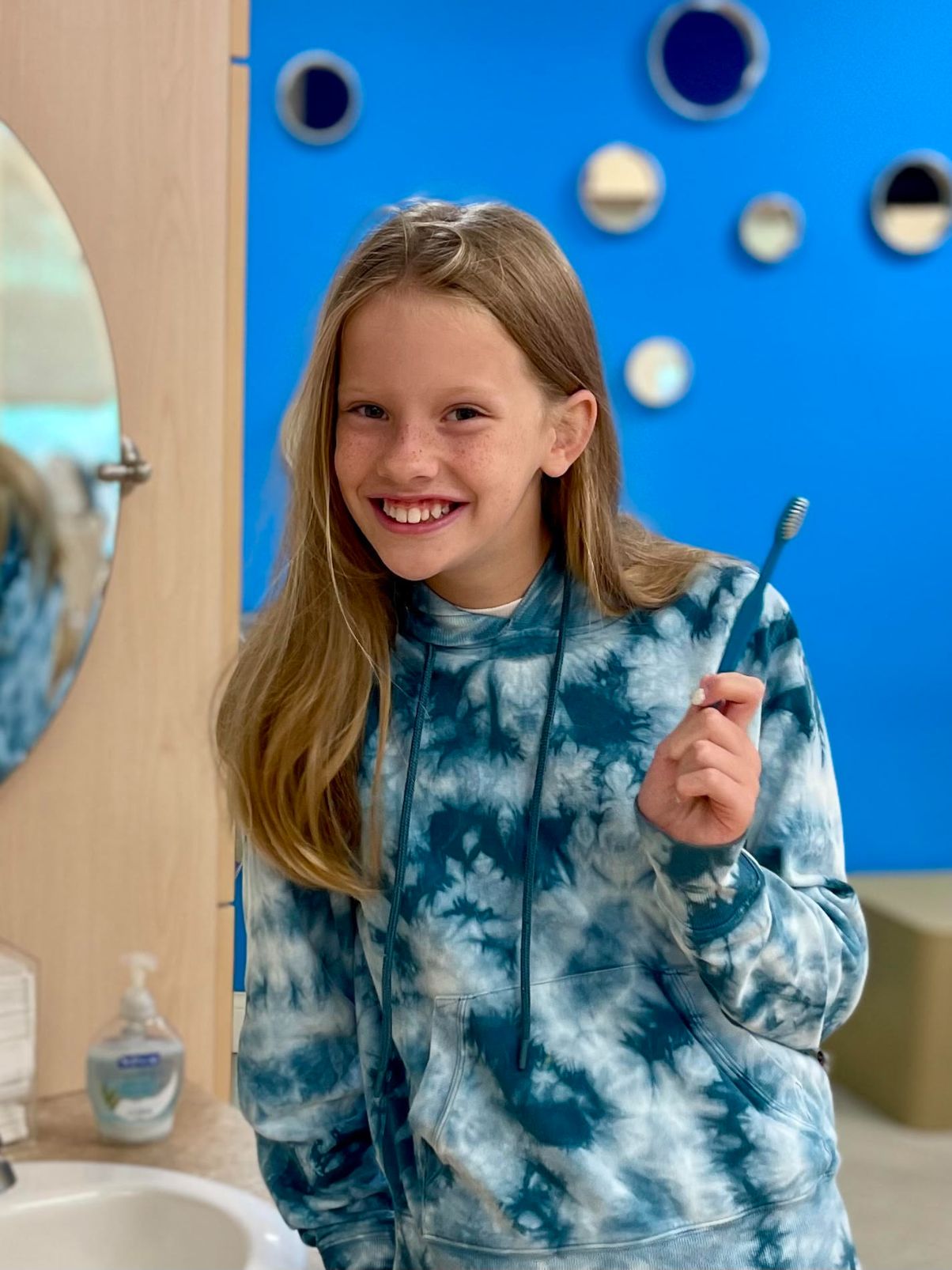 A girl holding a toothbrush in her hand.